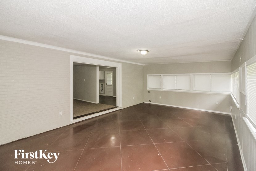 an empty living room with a large tile floor and white cabinets