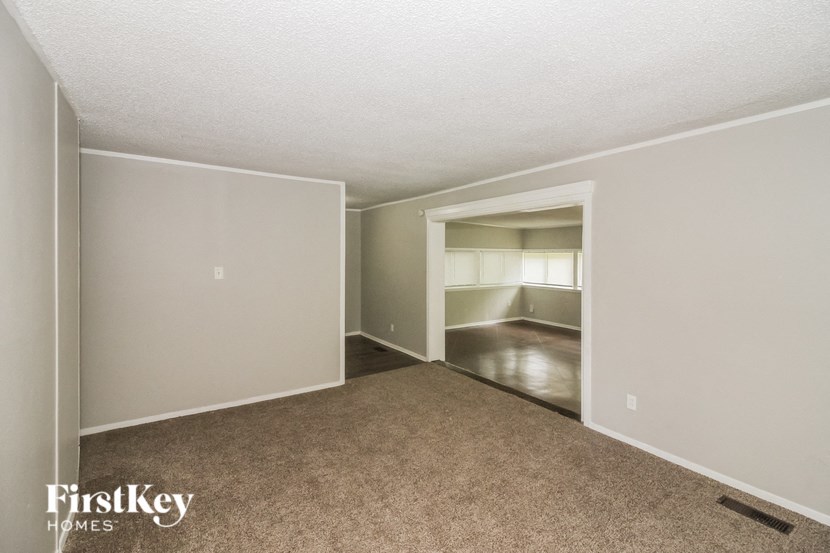 an empty living room with carpet and a closet