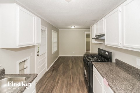 a kitchen with white cabinets and a black stove