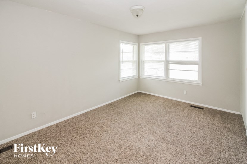 a bedroom with a carpeted floor and two windows