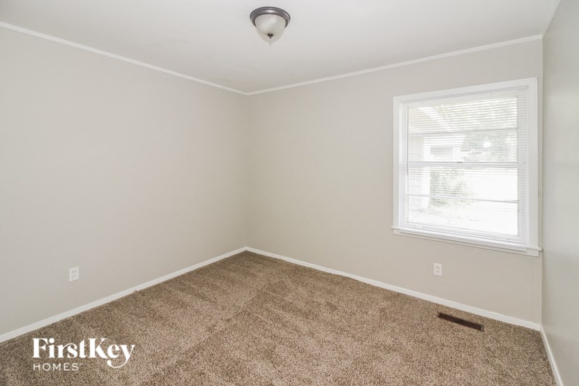 a empty room with a carpeted floor and a window