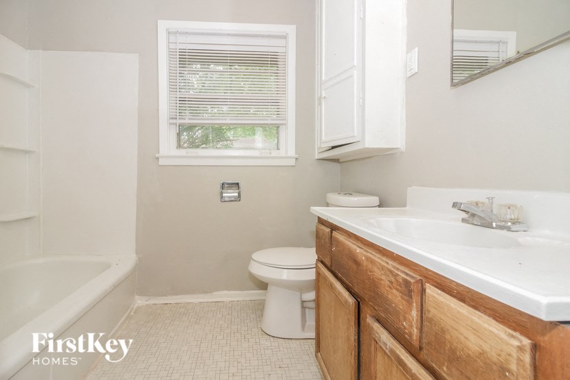 a bathroom with a toilet and a sink and a bath tub