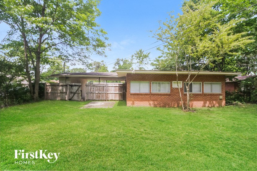 a small brick house with a yard in front of it