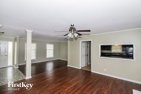 a living room with wood floors and a ceiling fan