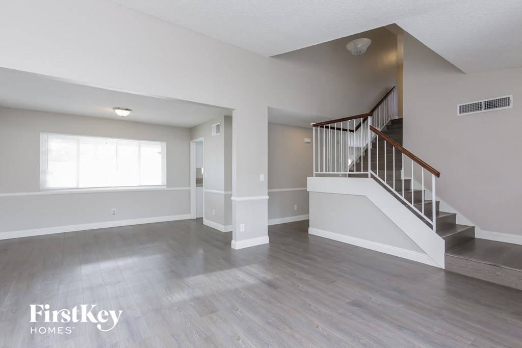 A spacious living room with a staircase leading to the upper floor.
