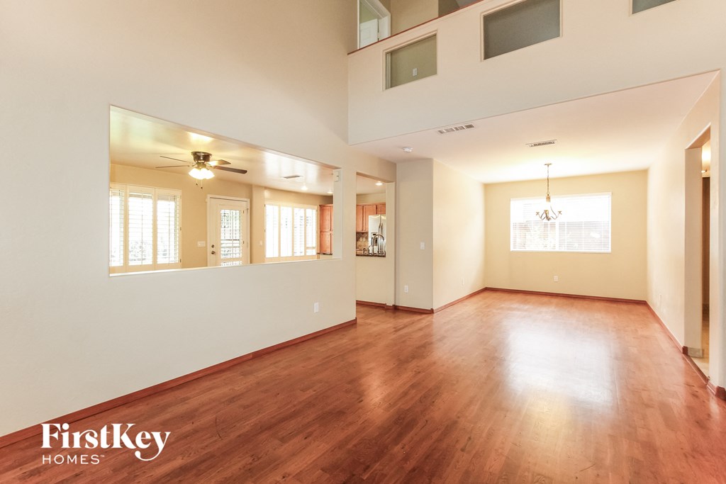 an empty living room with wood flooring and white walls