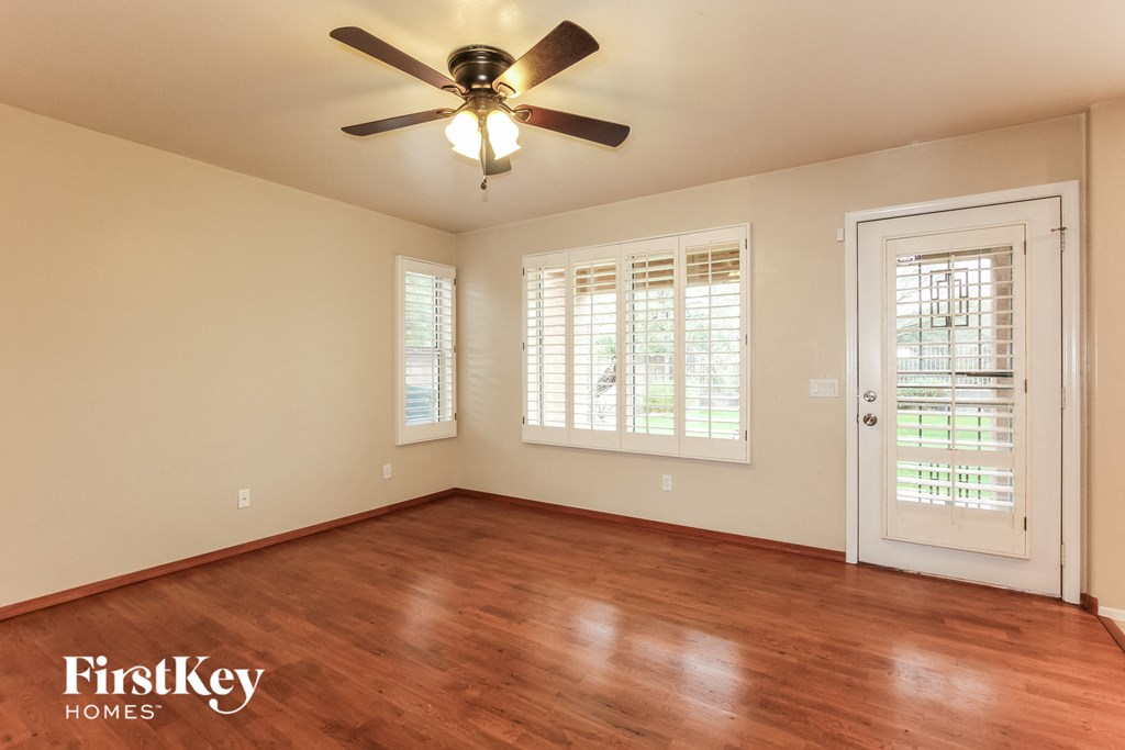a living room with wood floors and a ceiling fan