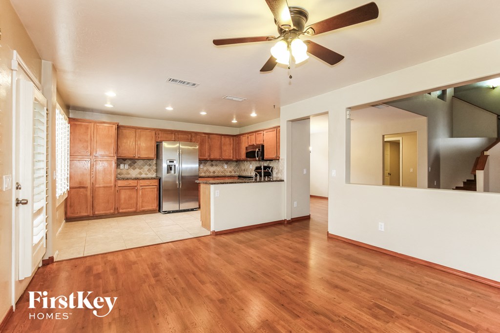 a kitchen and living room with wood flooring and a ceiling fan