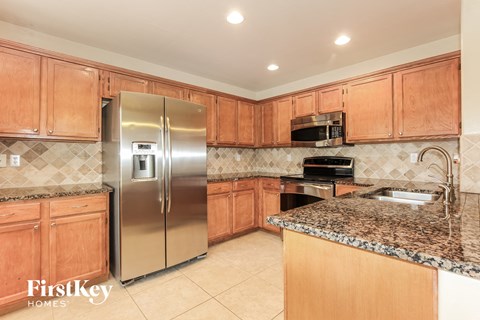 a kitchen with wooden cabinets and stainless steel appliances and granite counter tops
