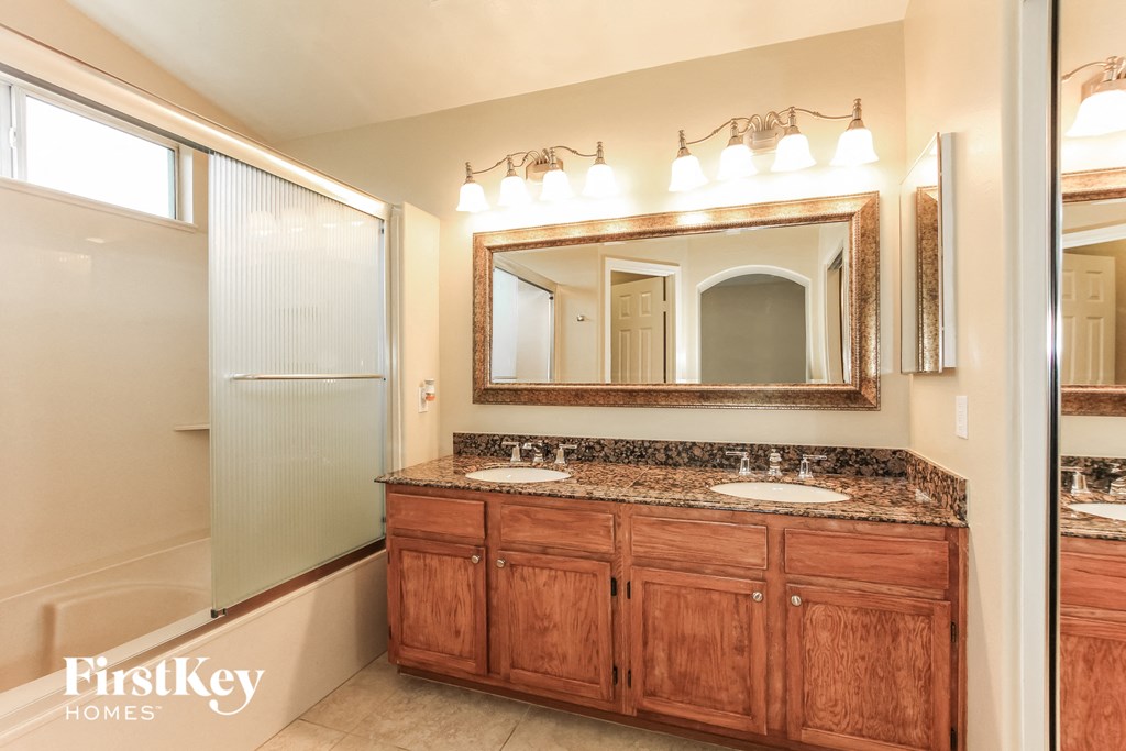 a bathroom with two sinks and a mirror and a shower