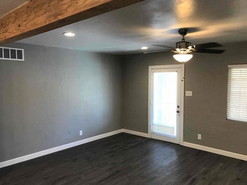 a living room with gray walls and a ceiling fan
