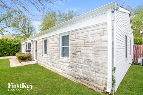 A small white house with a porch and a small window.