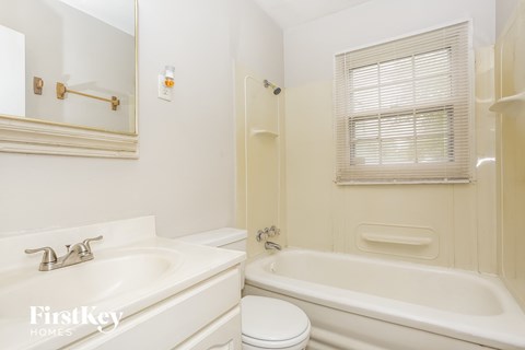 A white bathroom with a tub, toilet, and sink.