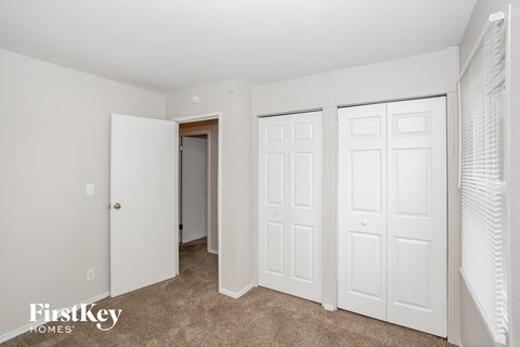 A white door is open in a room with a carpet floor.