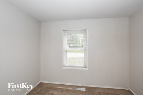 A room with a window and a carpet on the floor.