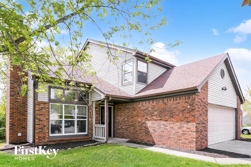 A house with a brick wall and a garage door.