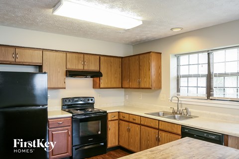 A kitchen with wooden cabinets and black appliances.