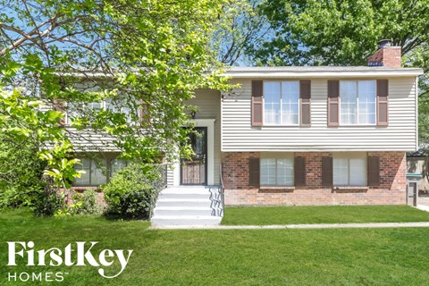A house with a white front porch and a brick chimney.