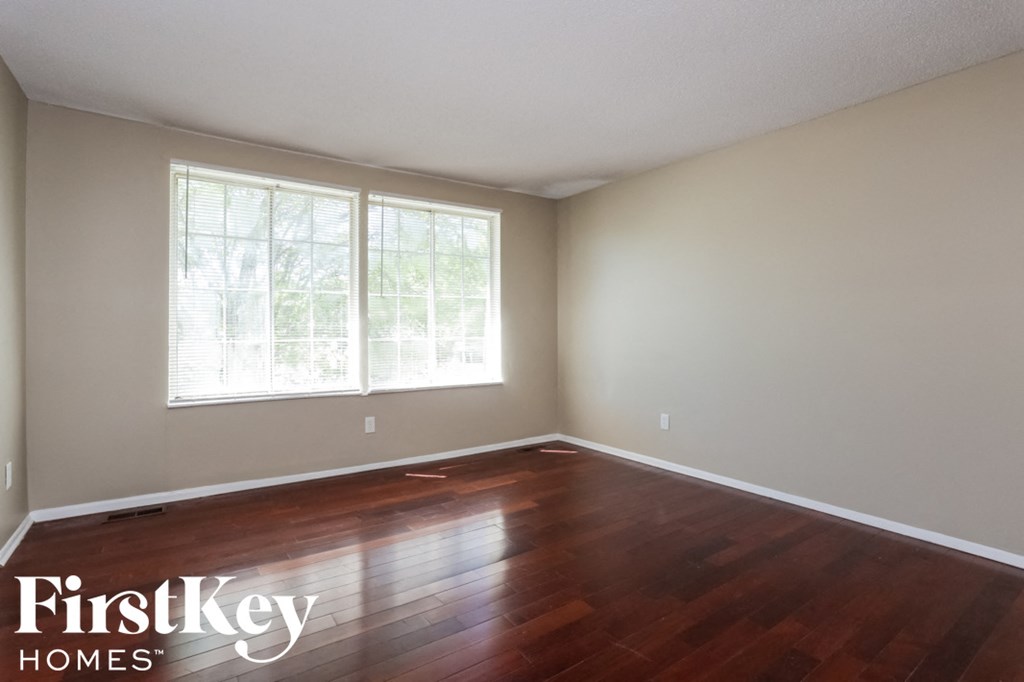 A room with wooden floors and a large window.