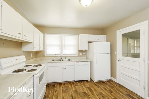 a white kitchen with white appliances and white cabinets