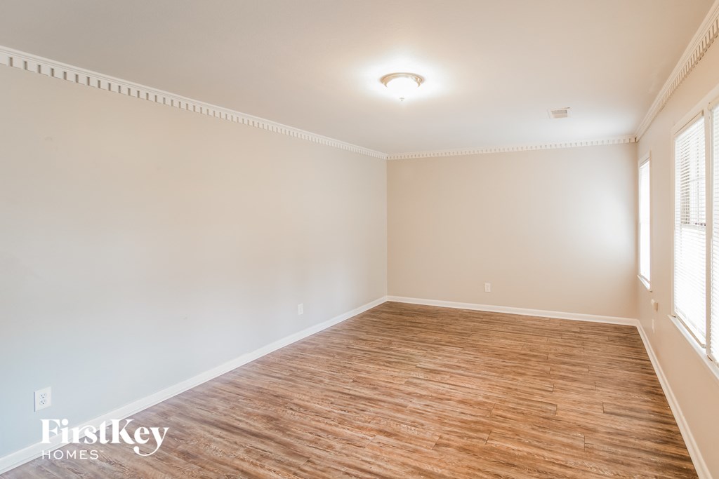 A room with wooden flooring and white walls.