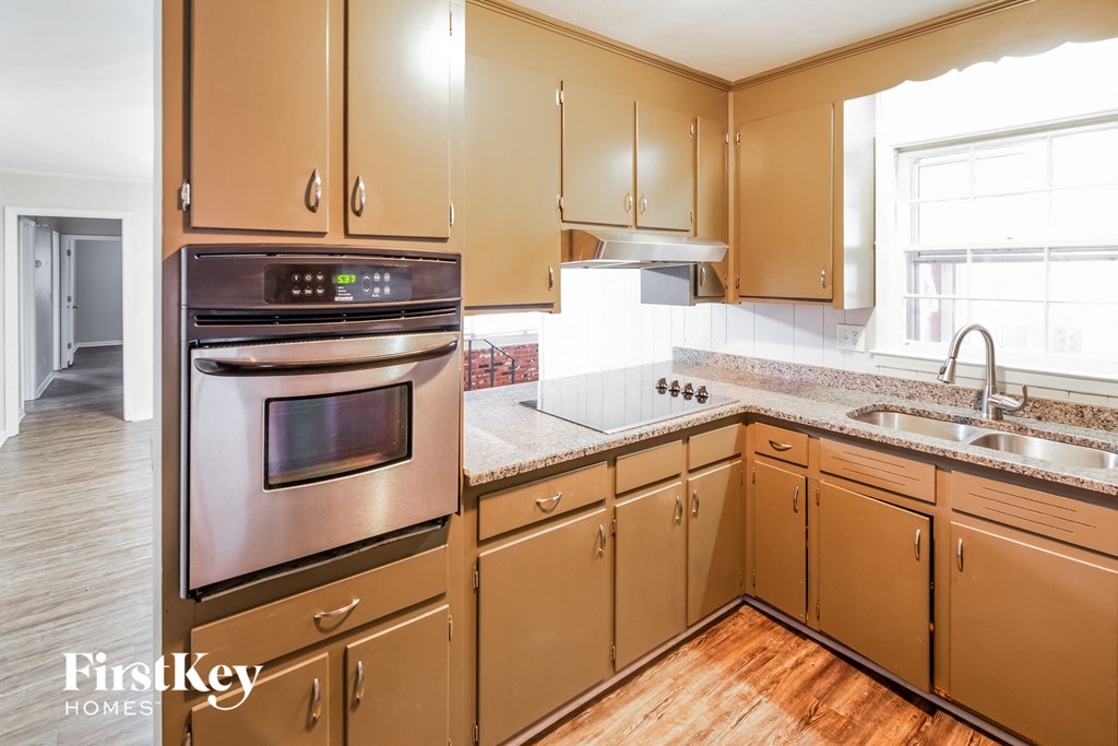 A kitchen with wooden cabinets and a stainless steel oven.