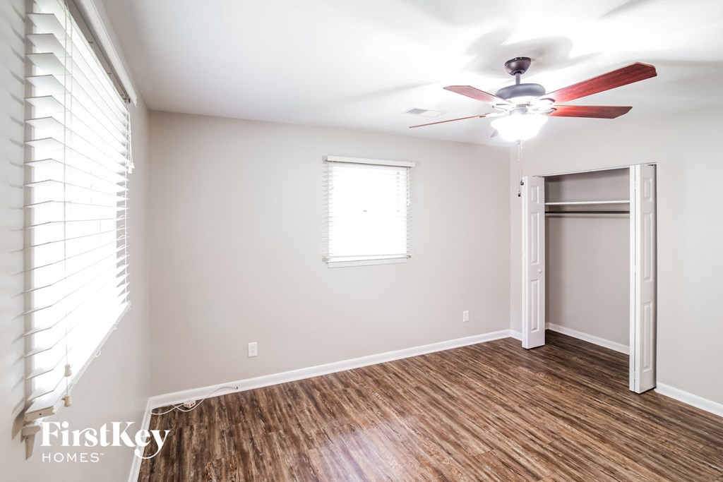 A room with a ceiling fan and a door.