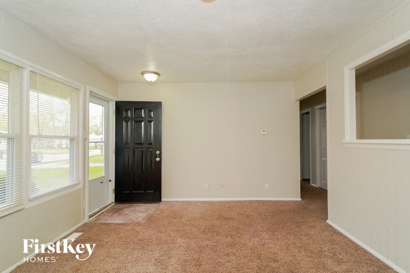 the living room of an empty house with a black door