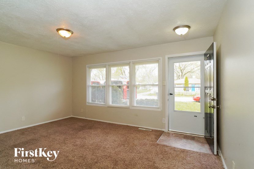 the living room of an empty house with a door and windows