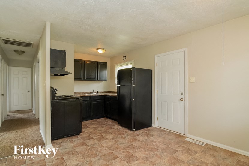 an empty kitchen with a refrigerator and a sink
