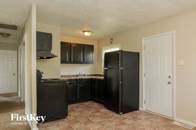 a kitchen with black appliances and a white door