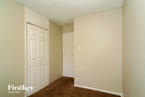 a bedroom with two closets and a door and a carpet
