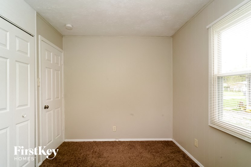 a bedroom with a carpeted floor and a white door