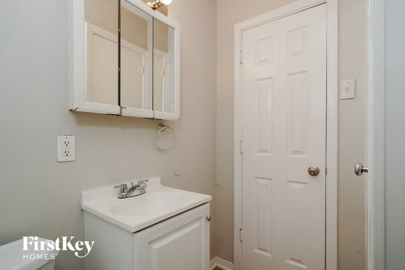 a bathroom with a sink and a white cabinet and a door