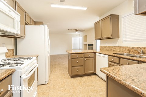 a large kitchen with white appliances and granite counter tops