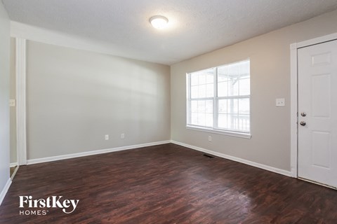 A room with wooden floors and a window letting in light.