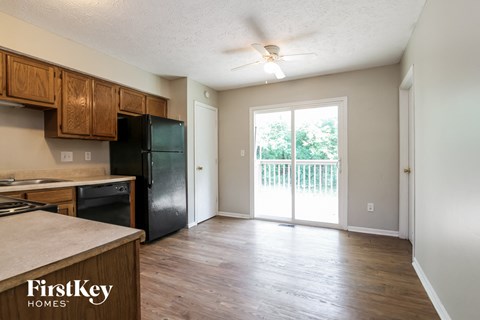 A kitchen with wooden cabinets and a black fridge.