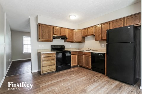 A kitchen with wooden cabinets and black appliances.