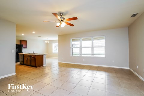 an empty kitchen and living room with a ceiling fan