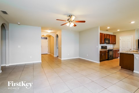 a kitchen and living room with tile flooring and a ceiling fan