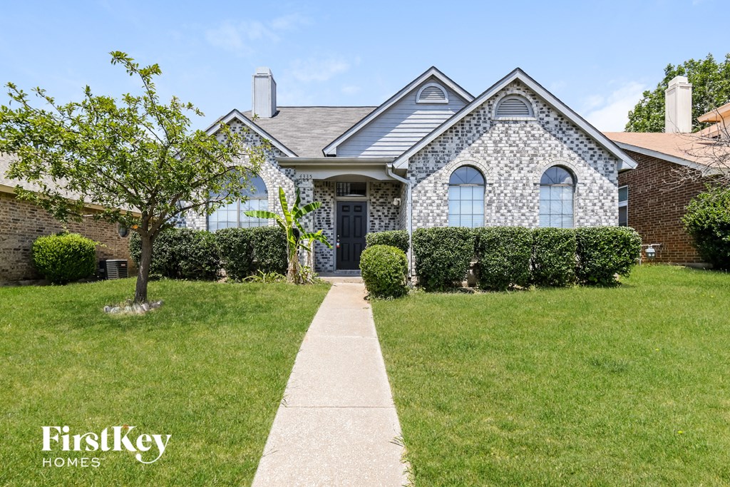 A house with a stone facade and a large front yard.