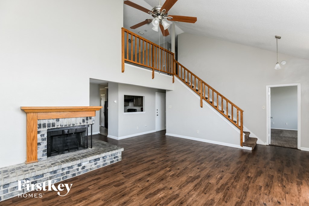 A living room with a fireplace and a staircase.