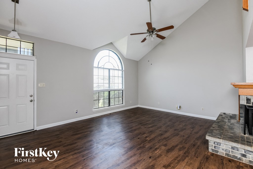 A room with a fireplace and a fan on the ceiling.