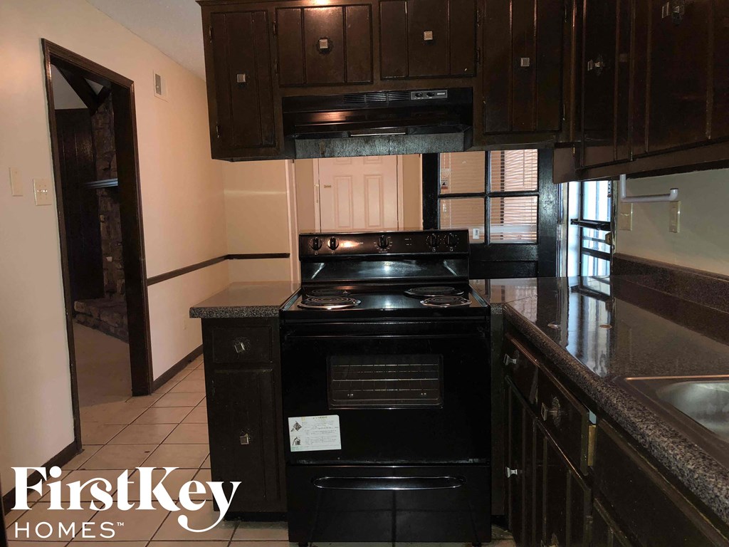 a kitchen with black appliances and dark wood cabinets