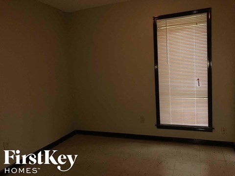 an empty room with a window and blinds in it