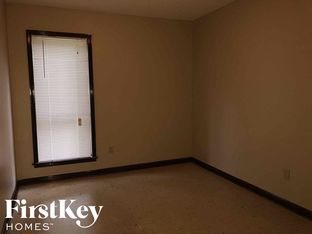 a empty room with a window and a wooden floor