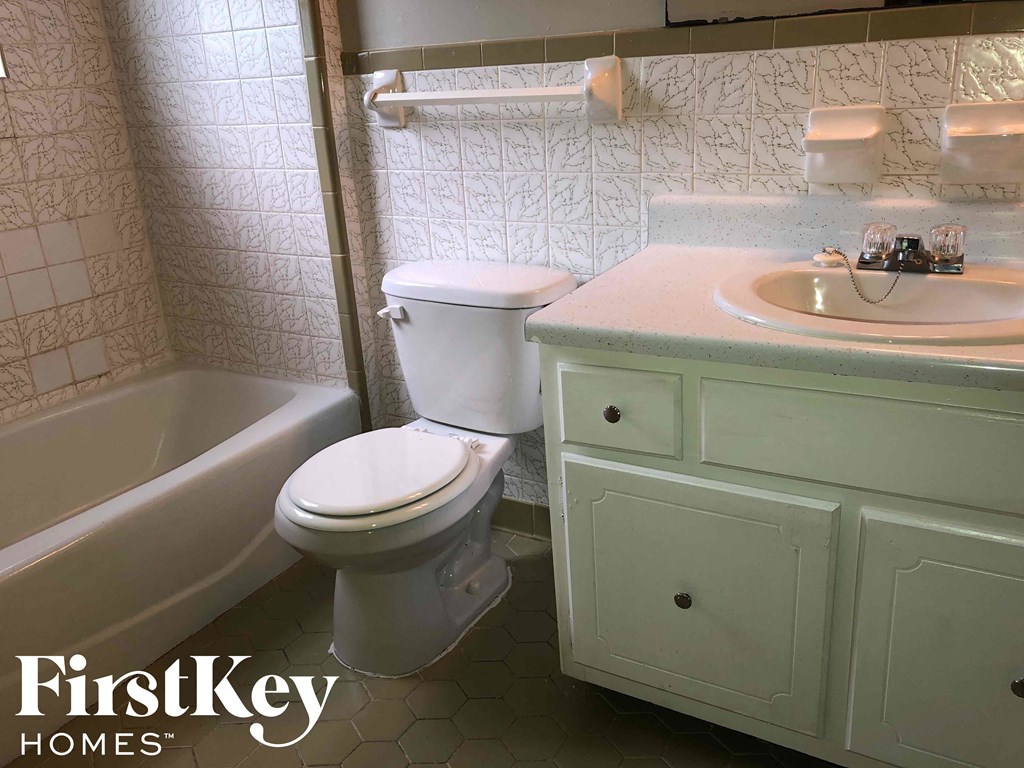 a bathroom with a toilet and a sink and a bath tub