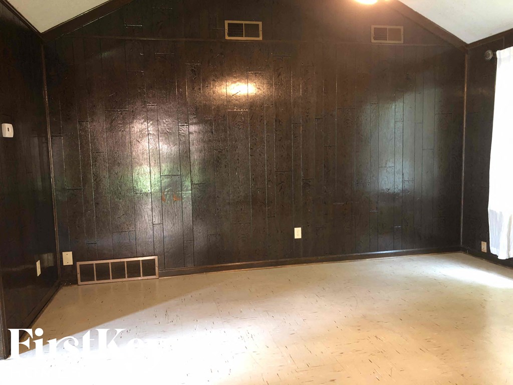 an empty room with black walls and a wooden floor