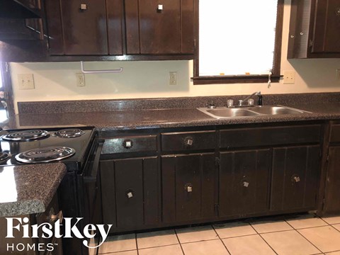 a kitchen with dark wood cabinets and a sink