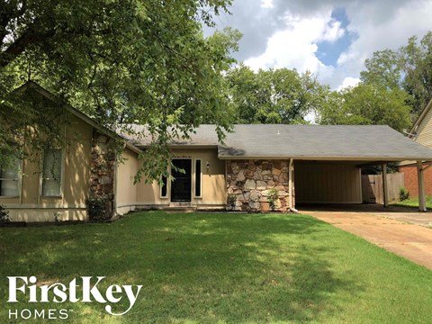 a house with a lawn and a stone wall